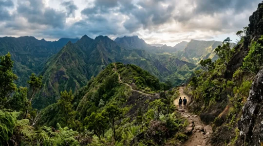Randonneurs sur un sentier de montagne dans le Parc National de la Réunion sous un ciel tropical