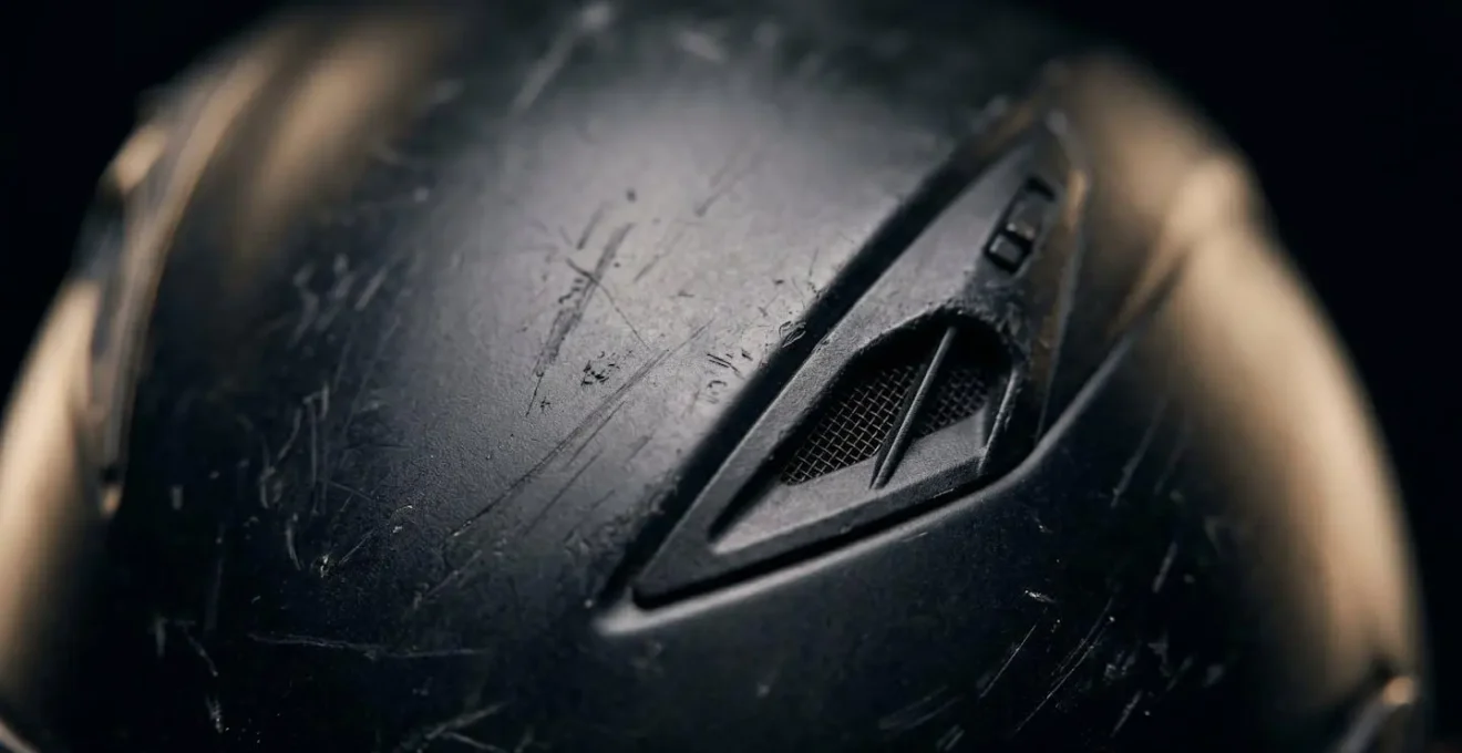 Gros plan macro sur la texture d'un casque de moto révélant les détails de surface et reflets
