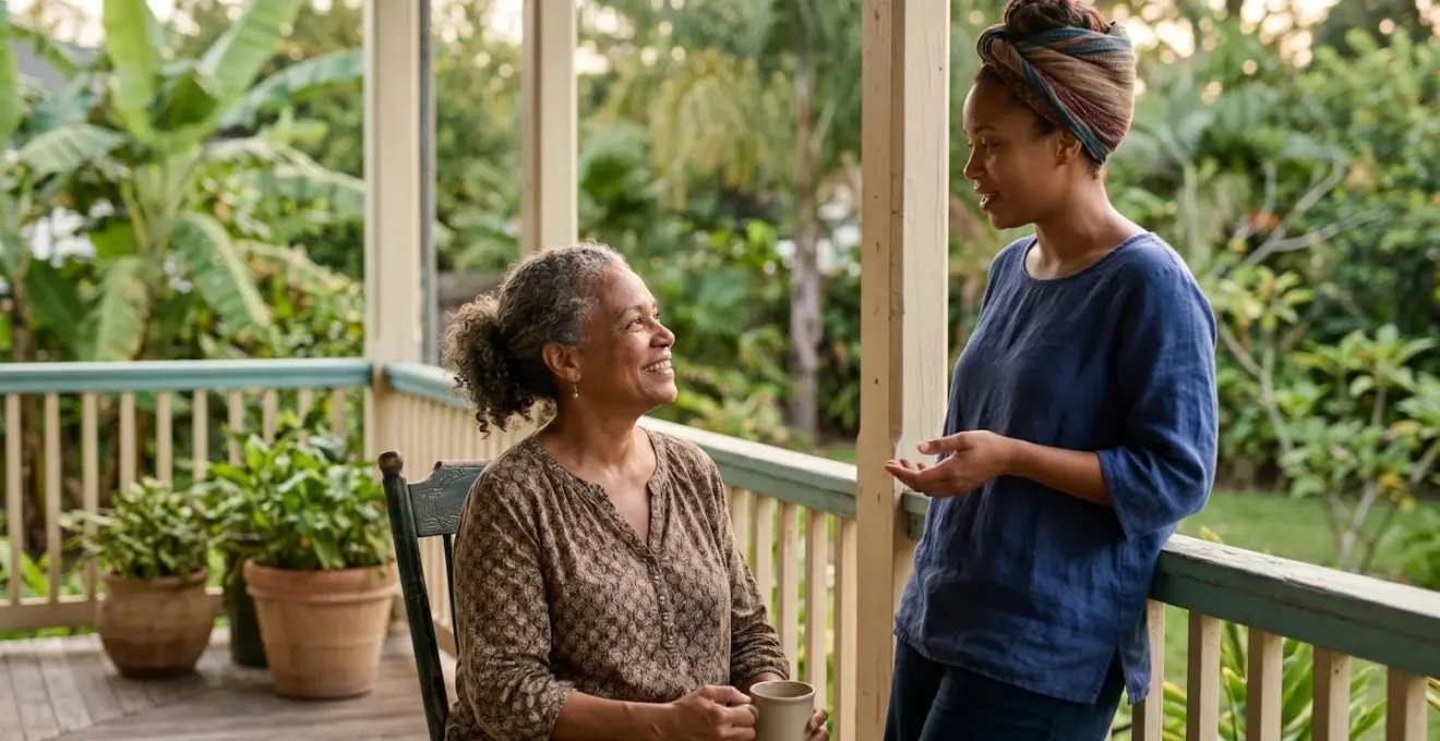 Rencontre chaleureuse entre voyageurs et propriétaire de gîte sur une terrasse créole