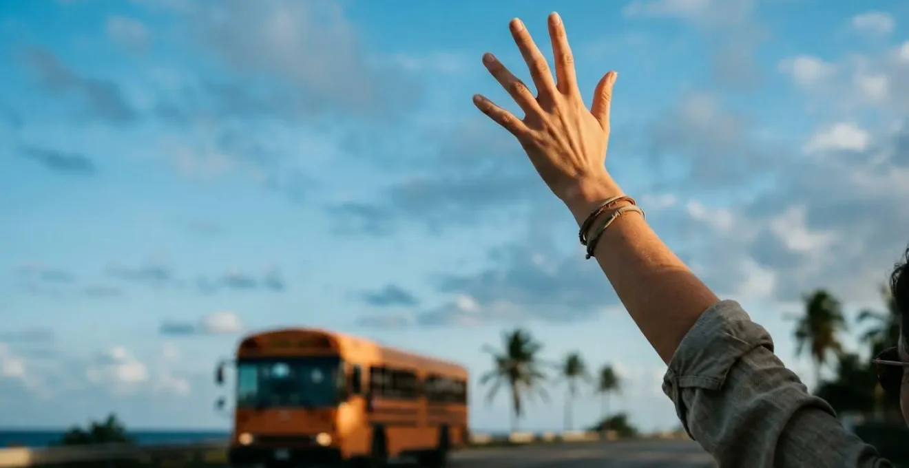 Passager levant énergiquement la main pour signaler au chauffeur de bus qu'il souhaite monter à l'arrêt