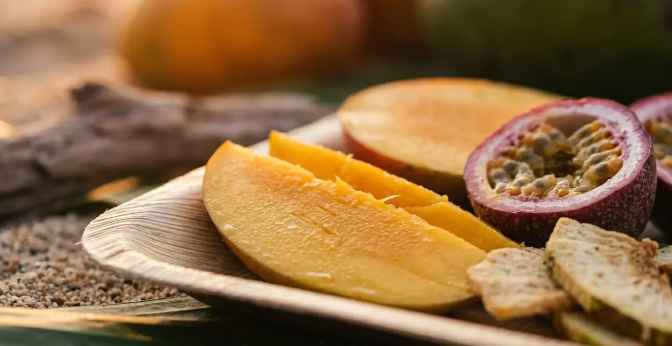 Gros plan sur des fruits tropicaux frais disposés sur une surface naturelle en bord de plage au coucher du soleil